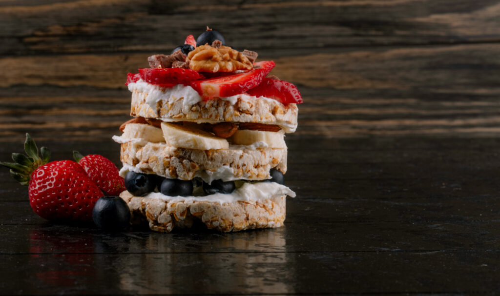 side view tasty crispbread with blueberries strawberries nuts with sour cream wooden rustic background with copy space