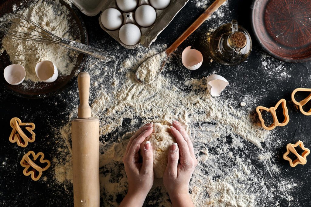 woman s hands knead dough table with flour eggs ingredients black table top view still life flat lay