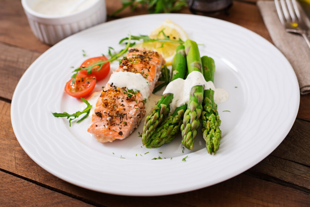 baked salmon garnished with asparagus tomatoes with herbs