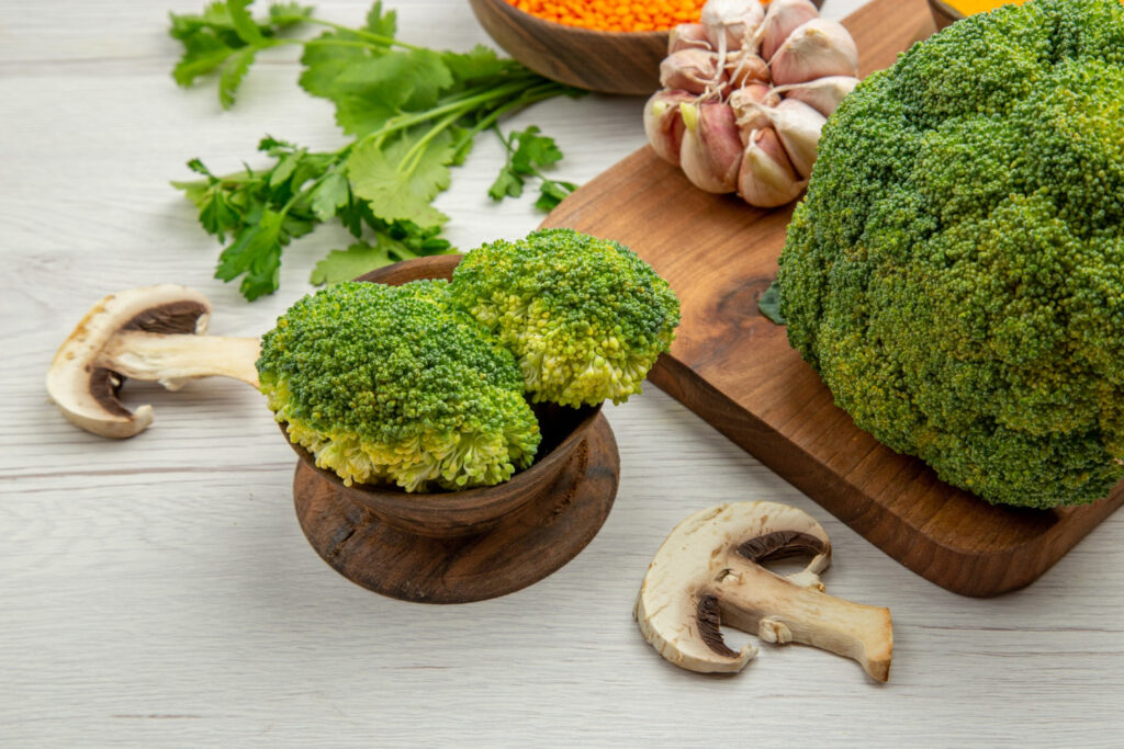 bottom view fresh broccoli garlic cutting board mushrooms parsley grey table