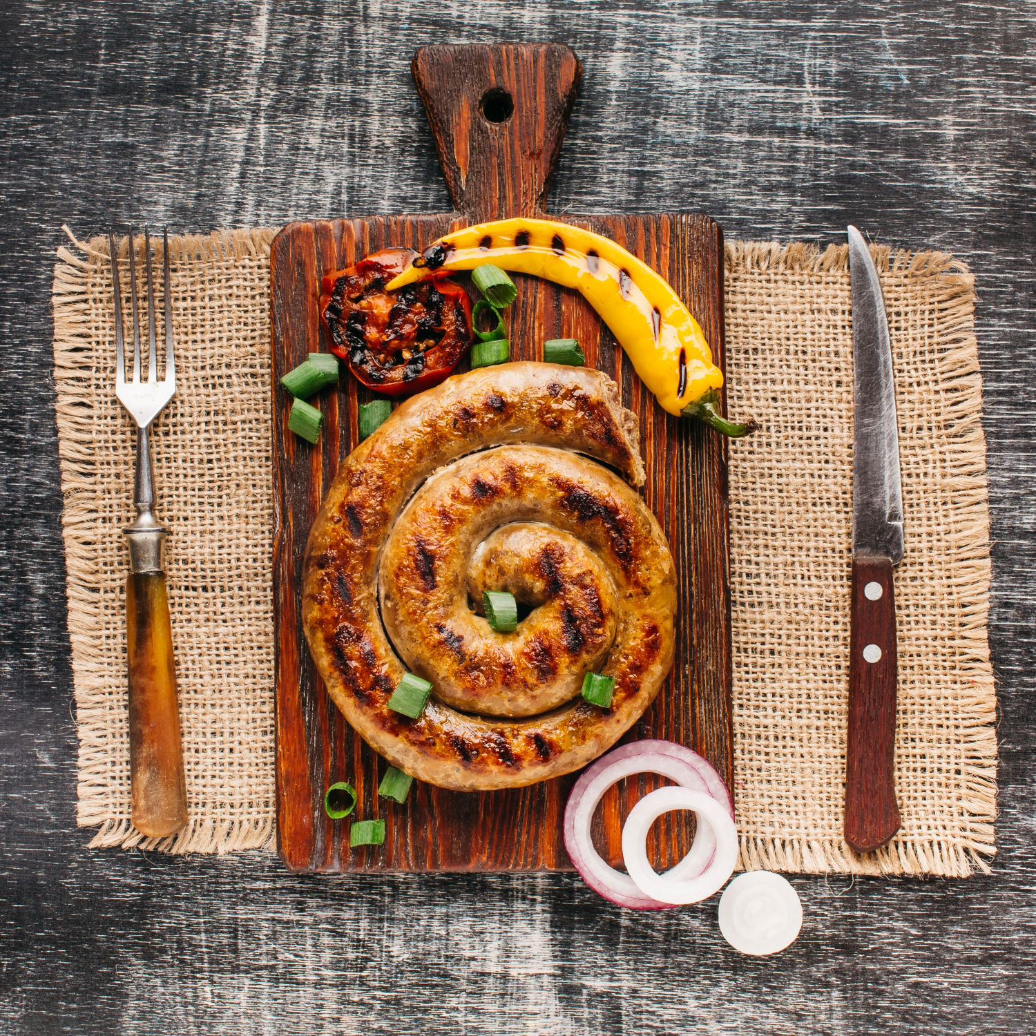 elevated view snail sausage wooden cutting board