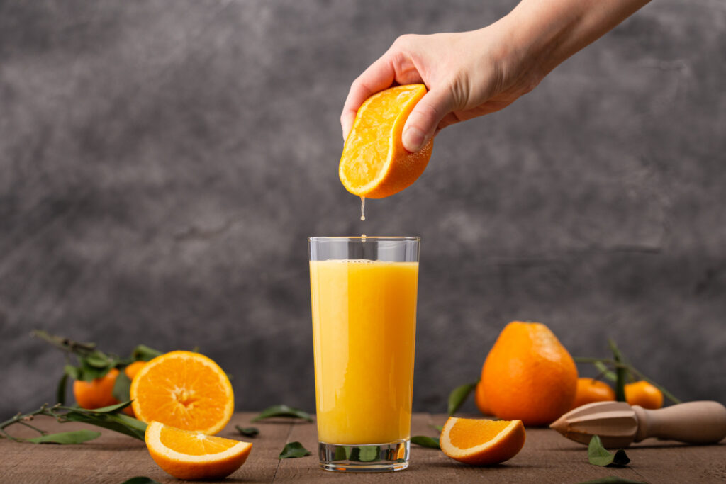 glass orange juice person squeezing orange it