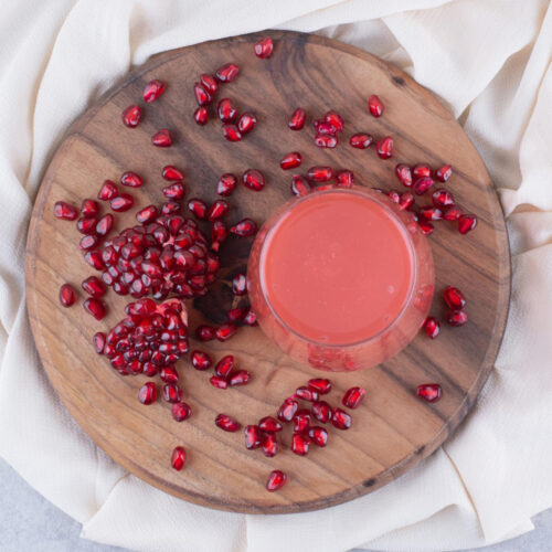 glass pomegranate juice wooden board with seeds high quality photo
