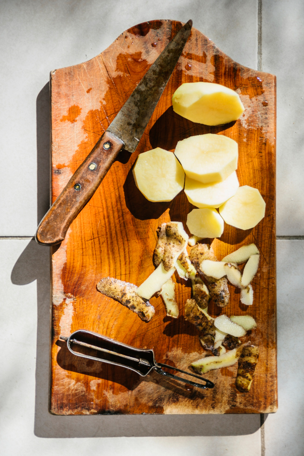 high angle view sliced potatoes with knife wooden cutting board