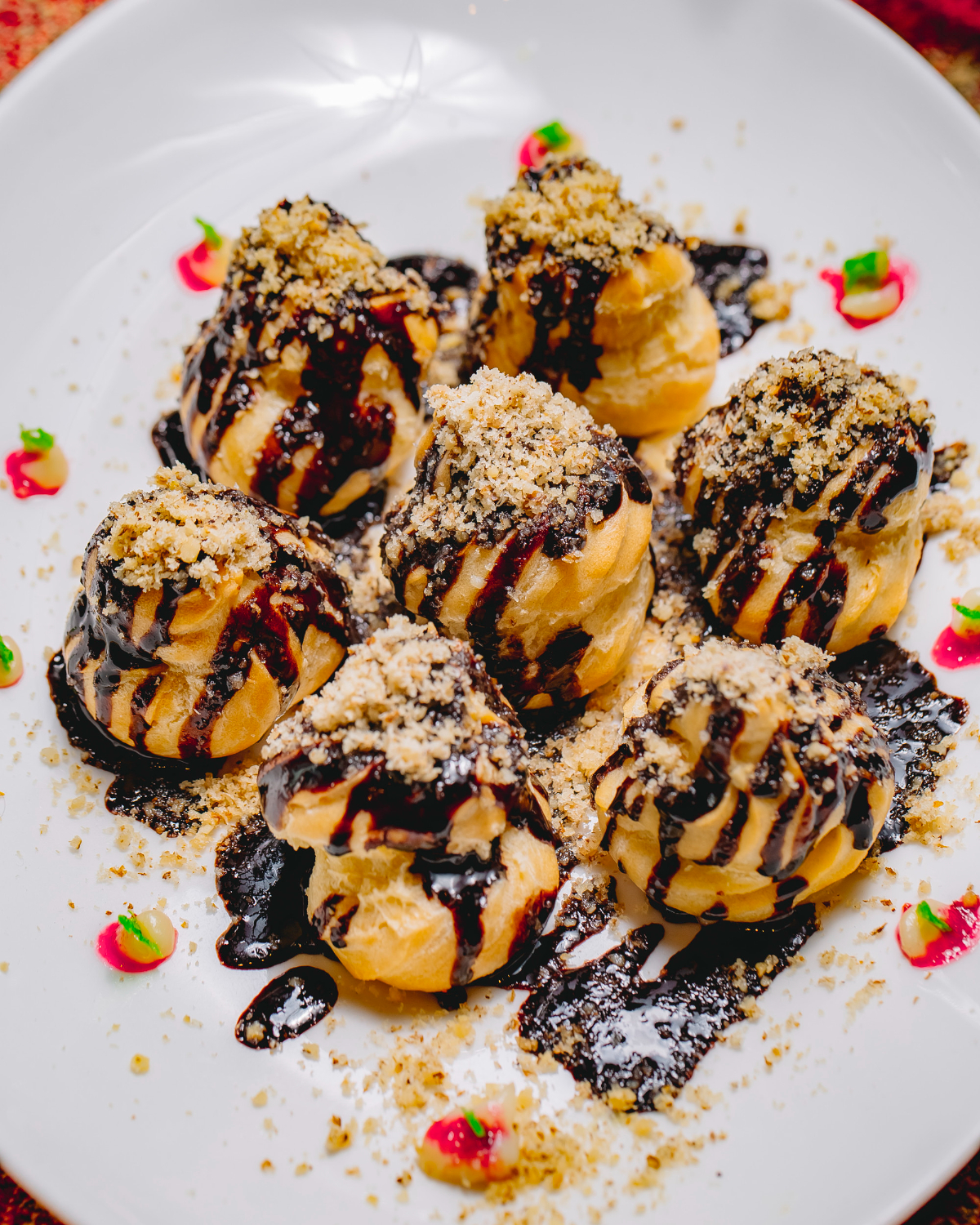 top view dessert profiteroles with chocolate icing grated nuts