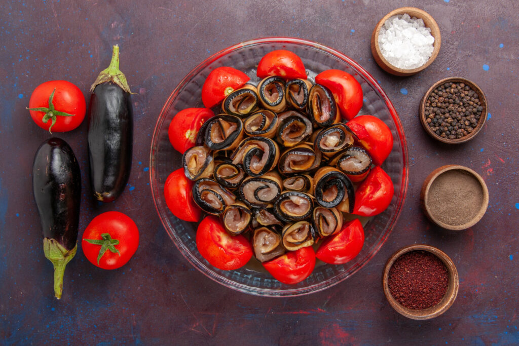 top view vegetable meal sliced rolled tomatoes with eggplants seasonings dark background
