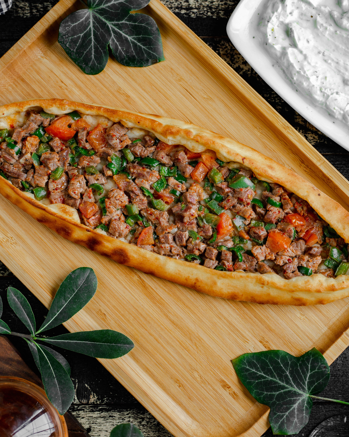 turkish pide pizza with meat vegetable stuffing inside wooden tray