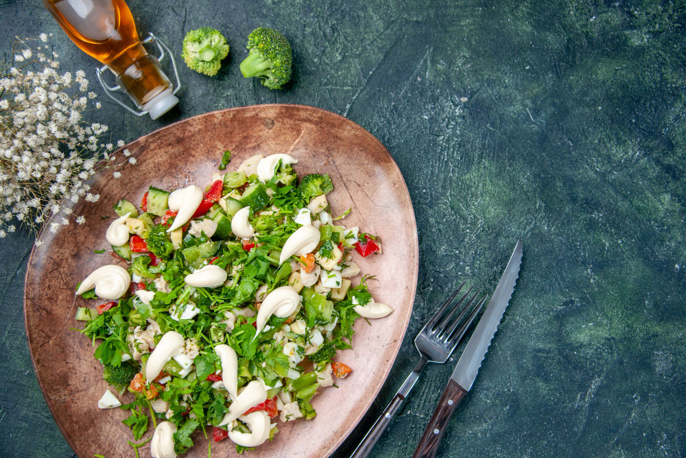 view fresh vegetable salad inside elegant plate with cutlery dark blue background