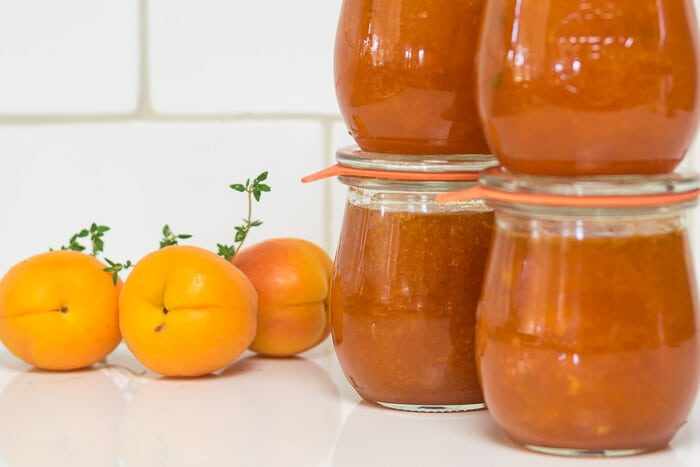 4 jars apricot jam in front of white tile 1 7