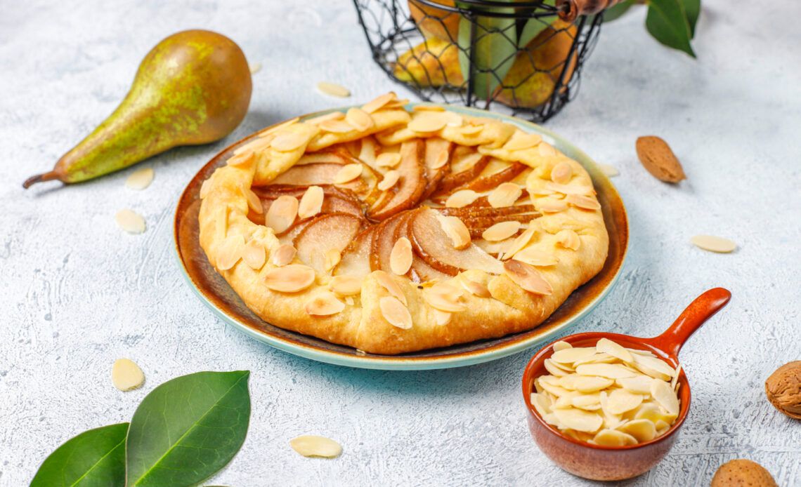 homemade pear galette pie with almond leaves fresh ripe green pears