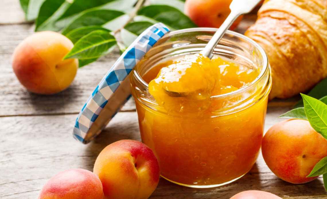 tasty fruit orange apricot jam glass jar with fruits wooden table closeup