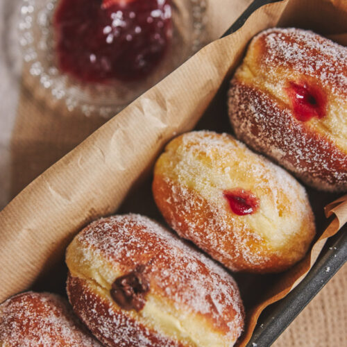 vertical closeup fluffy doughnuts filled with jam container lights